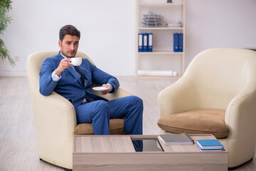 Young male employee waiting for business meeting