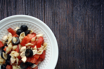 Italian salad with pasta, tomatoes and mozzarella. Culinary background.