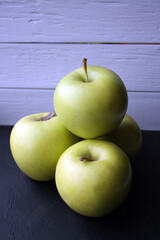 Juicy yellow apples on a black background.