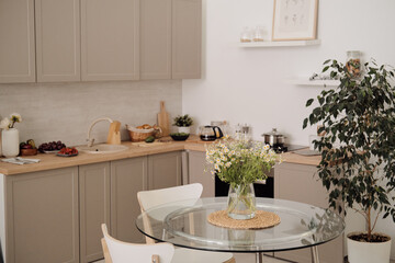 Interior of modern kitchen with chairs around table in the center