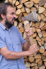 A bearded man in a rage wants to chop firewood