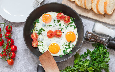 Fried eggs in a frying pan. On a concrete gray background. On the plate