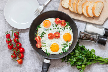 Fried eggs in a frying pan. On a concrete gray background. On the plate