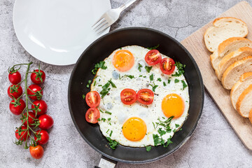 Fried eggs in a frying pan. On a concrete gray background. On the plate