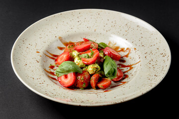 Caprese salad with strawberries. Salad with mozzarella, tomatoes, basil and strawberries.