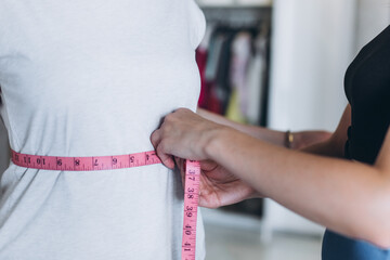 Young girl's waist is measured with a centimeter