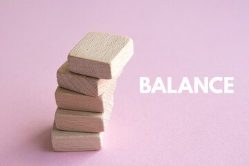 Stack of wooden cubes on a pink background. Balance concept