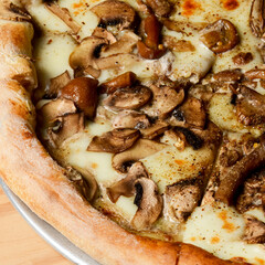 Appetizing pizza with mushrooms on a rustic wooden background. Delicious vegetarian pizza.