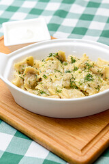 Italian ravioli with spinach and cheese close-up, rustic style. Served in a white pan over rustic wooden board