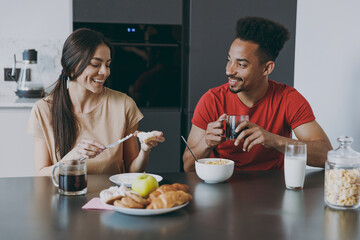 Young couple two woman american african man in casual clothes eat breakfast muesli drink coffee...