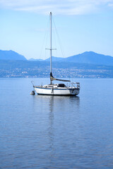 Fototapeta premium Lake Geneva at Lausanne on a cloudy summer day with sailing yacht in the foreground. Photo taken August 11th, 2021, Lausanne, Switzerland.