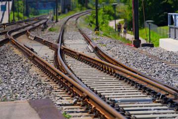 Fototapeta premium Tracks and railway switch at train station of Nyon on a sunny summer afternoon. Photo taken August 11th, 2021, Nyon, Switzerland.