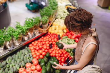 Top side view young happy vegetarian woman wear casual clothes shopping at supermaket greengrocery store buy choose vegetables avocado inside hypermarket. People lifestyle purchasing food concept