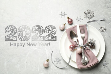 Happy New 2022 Year! Beautiful table setting and festive decor on light grey marble background, flat lay