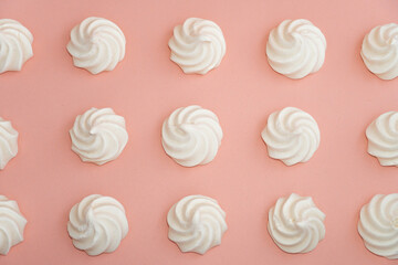 Closeup of french mini meringues cookies on pink as food background.