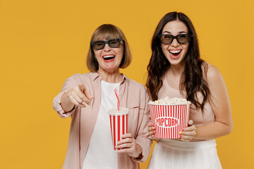 Two young laughing daughter mother woman in 3d glasses watch movie film hold bucket of popcorn cup...