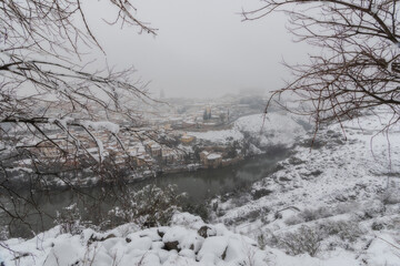 City landscape of snowy old city with clouds and snow; Cathedral and Alcazar of Toledo during the storm Filomena, World Heritage Site, Spain. Horizontal view