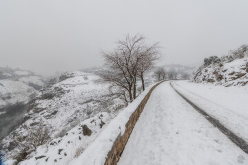 Obraz premium Snow covered road city landscape of snowy old city with clouds and fog; Valle road looking at the 