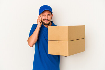 Young caucasian delivery man with tattoos isolated on white background  covering ears with hands.