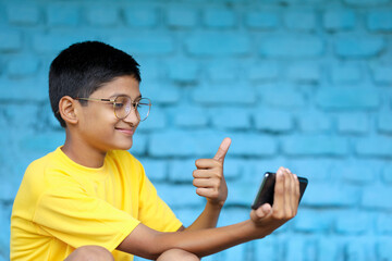 Cute Indian child using smartphone. online education concept
