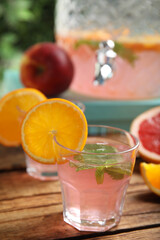 Delicious refreshing drink with orange and mint on wooden table