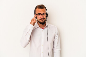 Young caucasian telemarketer man with tattoos isolated on white background  pointing temple with finger, thinking, focused on a task.