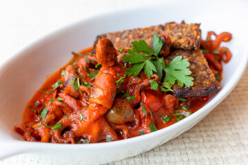 octopus; cherry tomatoes; olives; capers; tomato sauce; ready to eat; tasty; italian cuisine; recipe; traditional; gourmet; restaurant; dish; food; fish food; bruschetta; crusty bread; gravy; cooked