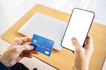 Online payment. Close Up man hands holding smartphone with blank screen and credit card, making financial transaction, smart phone for online shopping or reporting lost card