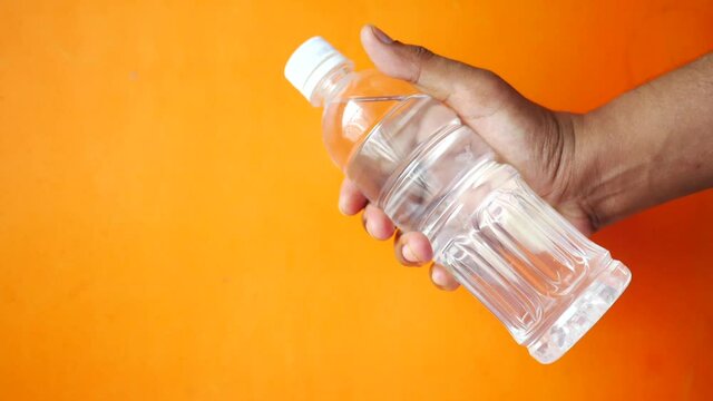 hand hold fresh drinking water in a plastic bottle 