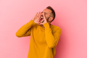 Young caucasian man with tattoos isolated on pink background  shouting excited to front.