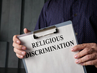Papers about religious discrimination in the lawyer hands. - obrazy, fototapety, plakaty