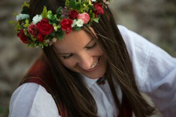 Face of  a  happy woman in a Latvian folk costume with flower wreath