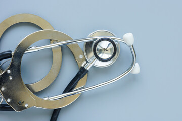 Medical negligence or error concept. Handcuffs and stethoscope.
