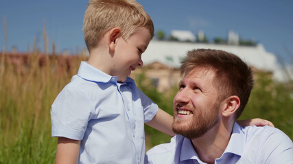 Happy caucasian father and son portrait playing together outdoors