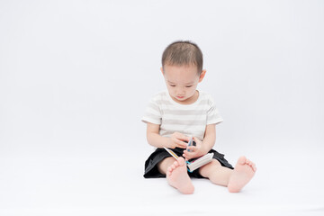 A little asian boy takes a portrait in a white background shed