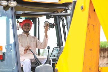 Indian man working with heavy equipment vehicle at construction site.