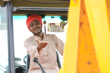 Indian man working with heavy equipment vehicle at construction site.