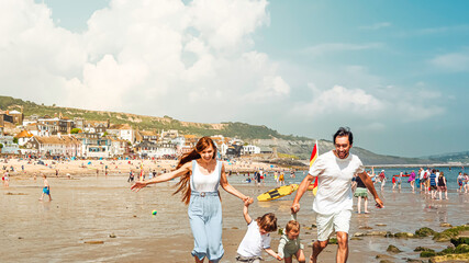 A young family is happy and enjoying thier summer holidays in Lyme Regis, United Kingdom on a hot summer day