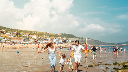 A young family is happy and enjoying thier summer holidays in Lyme Regis, United Kingdom on a hot summer day