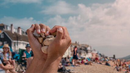 Hands in a heart shape at Lyme Regis touristic beach in July middle of summer in the United Kingdom