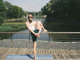 young woman doing yoga in the park outdoors
