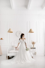 Fototapeta na wymiar The bride in a white dress with a bouquet of gypsophila