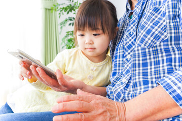 おばあちゃんとスマホを使う子供