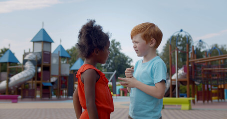 Cute multiethnic kids playing together on playground