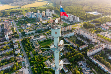Aerial view of a meteorological mast with a flag of Russia and a panorama of urban development in...