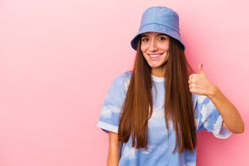 Young caucasian woman isolated on pink background smiling and raising thumb up