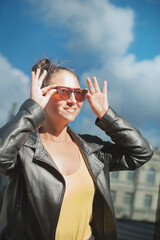 Beautiful happy woman with sunglasses on the sky background