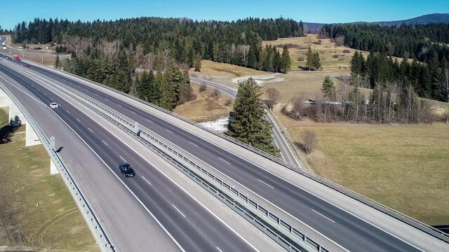 Old road and new highway from Krakow to Zakopane in Poland, called Zakopianka with viaducts, elevated crossroads and cars. Aerial 4K video in winter.