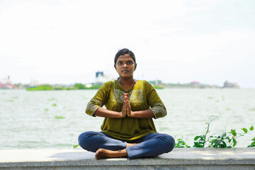 girl meditating on beach