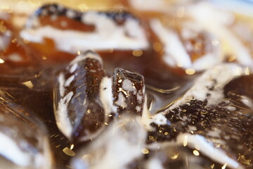 Close-up pictures of ice floating on Americano coffee.